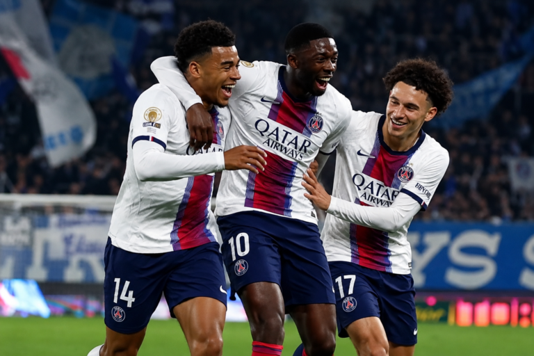 Three PSG players in white kits celebrating together on the pitch.